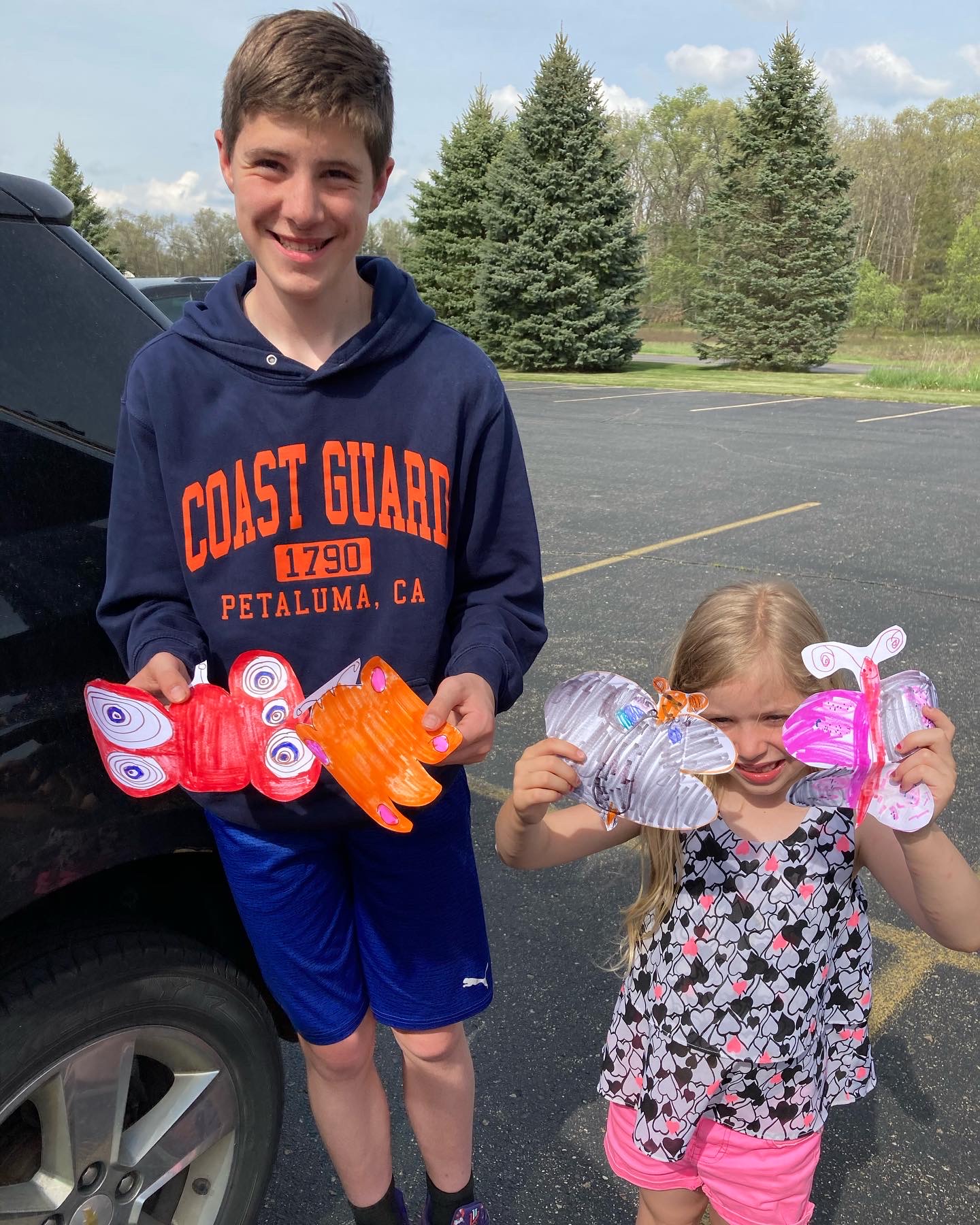 Boy and girl holding butterflies they made.